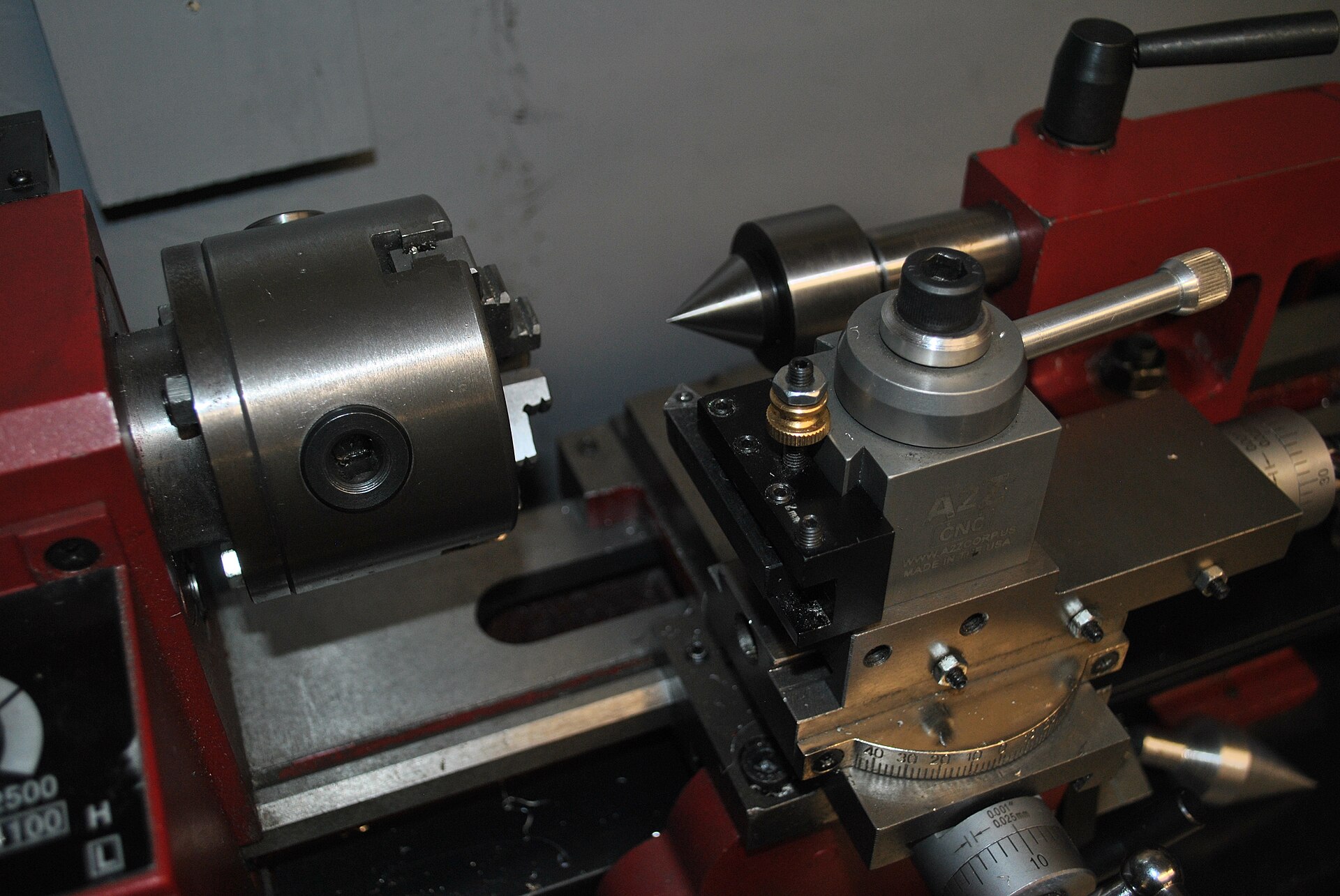 Figure 4 — A mini-lathe headstock and chuck at close range, showing the spindle nose, the three-jaw chuck, and the front control area. Source: Wikimedia Commons.
