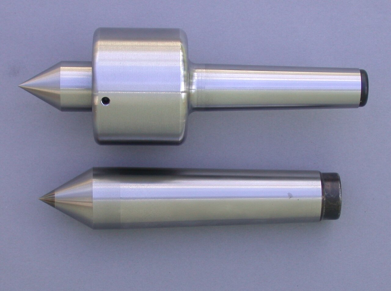 Figure 3 — Lathe centers: a dead center (solid, does not turn) and a live center (point rotates on its own bearings). The tailstock supports the free end of long work on one of these. Source: Wikim…